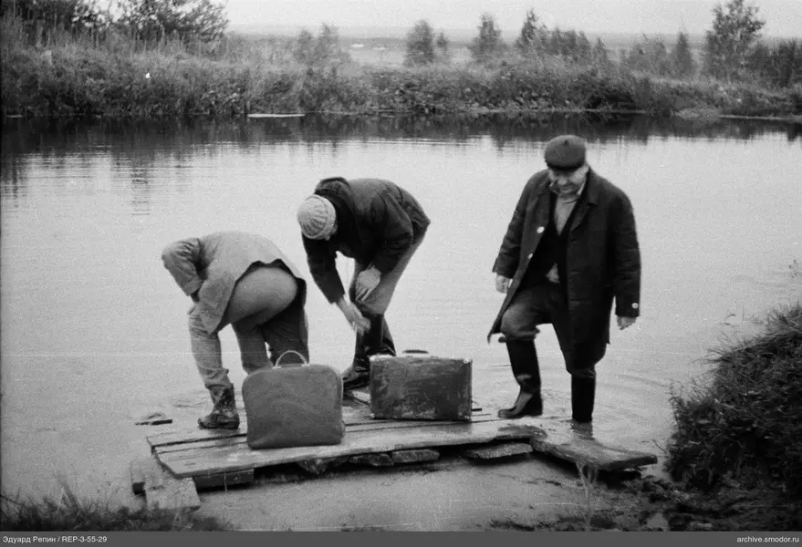 Drei Männer auf einer Holzplattform am Wasser