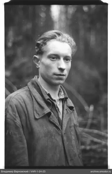 Man in dark coat against blurred trees