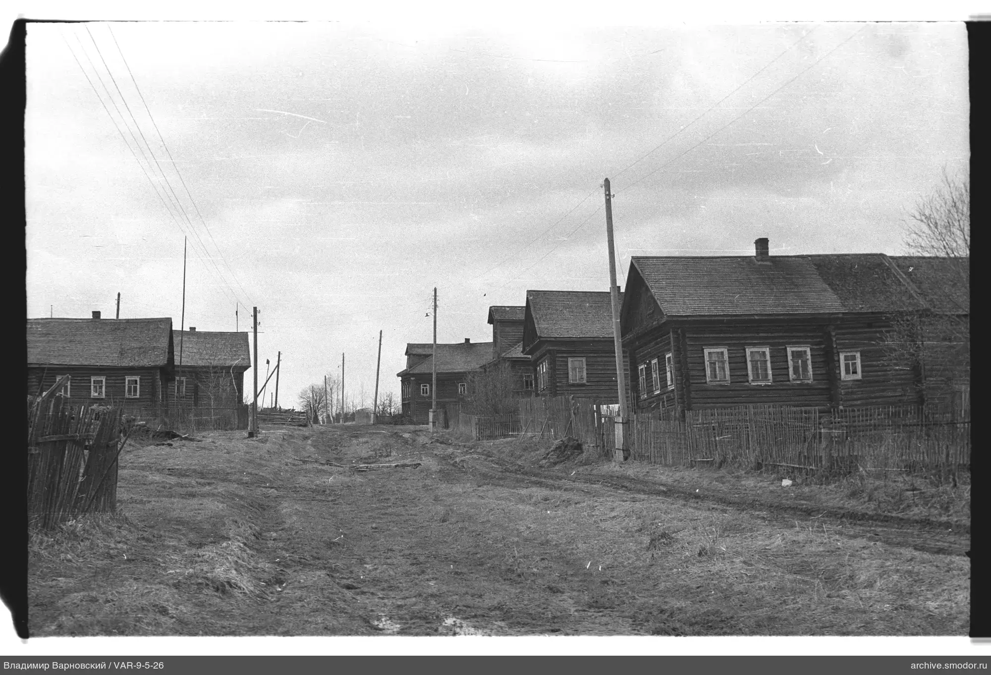 Holzhäuser und Straße mit Drähten