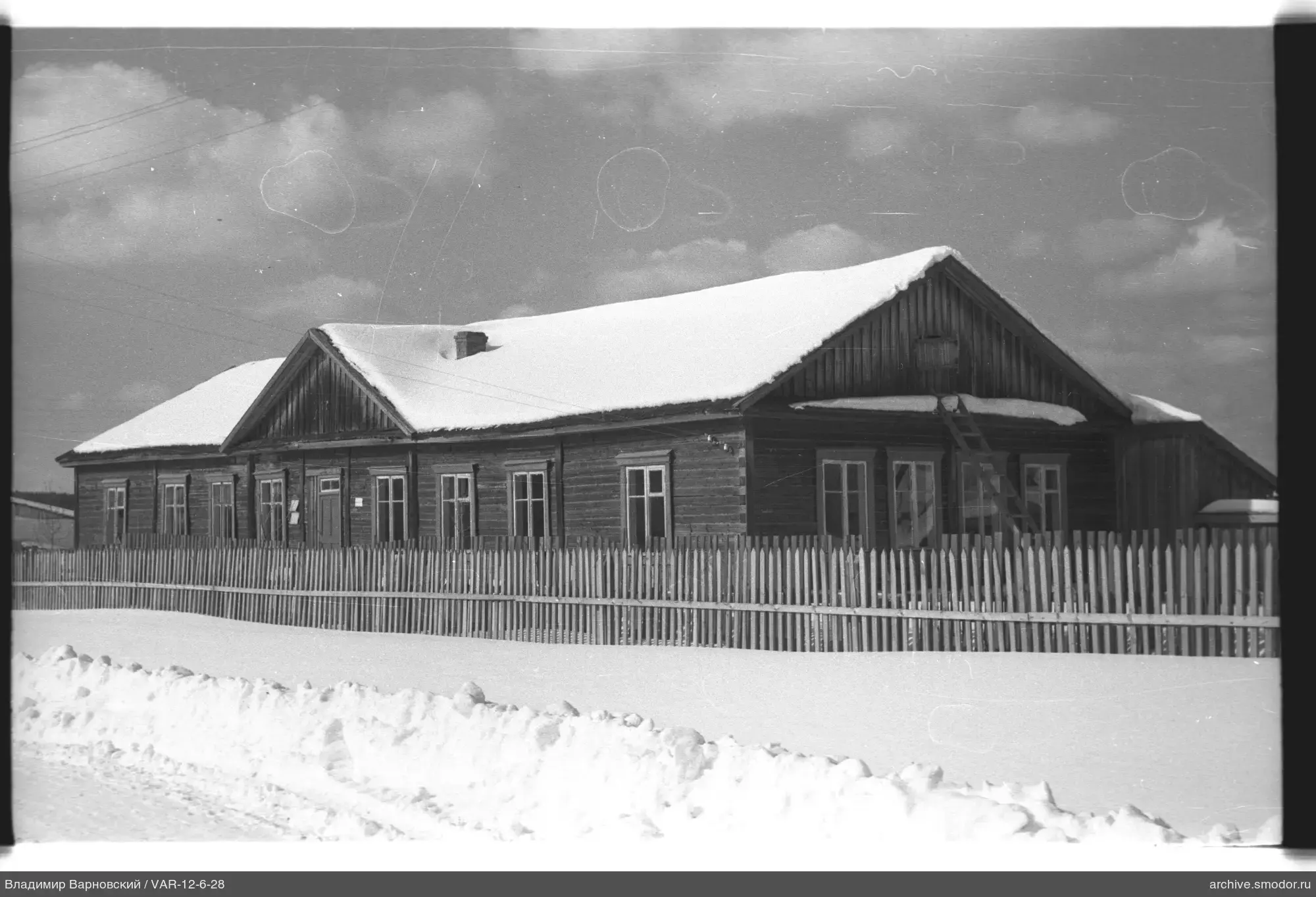 Wooden house with snow-covered roof