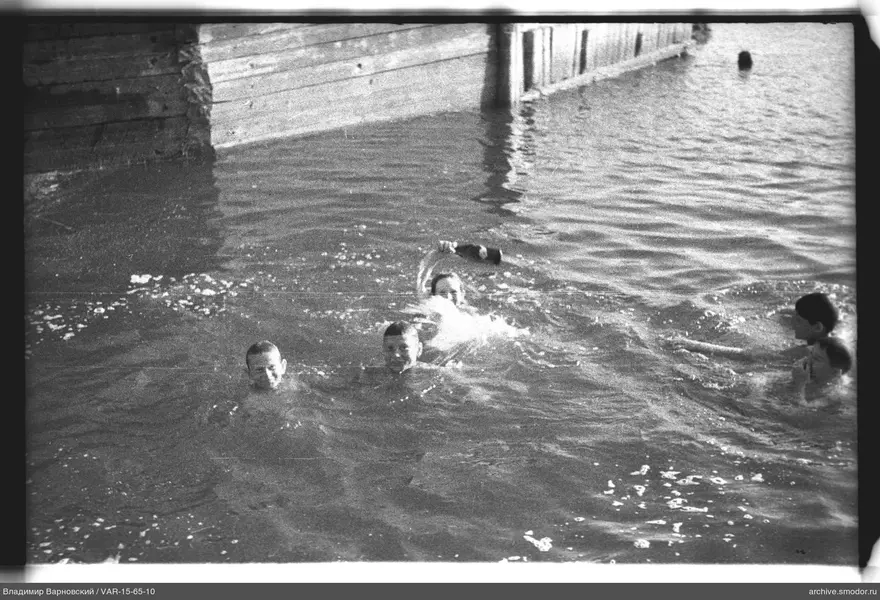 Fünf Jungen im Wasser bei einem Pier
