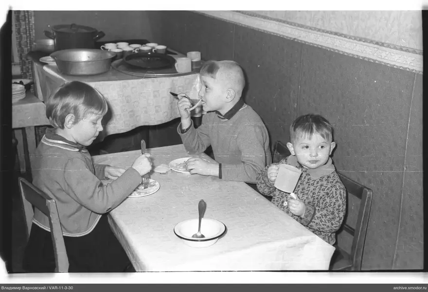 Children sitting at a table with dishes