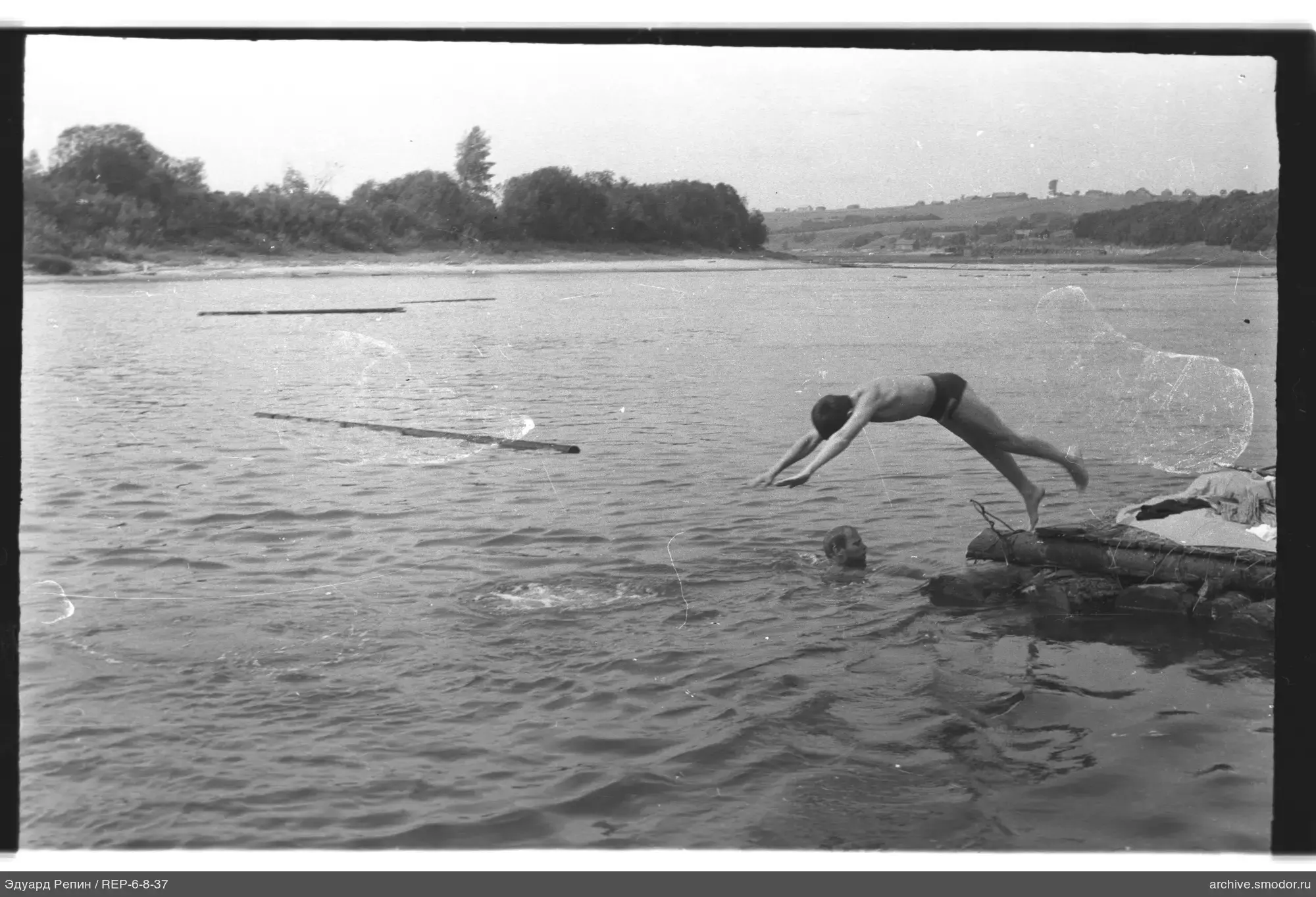 Мальчик прыгает в воду с причала