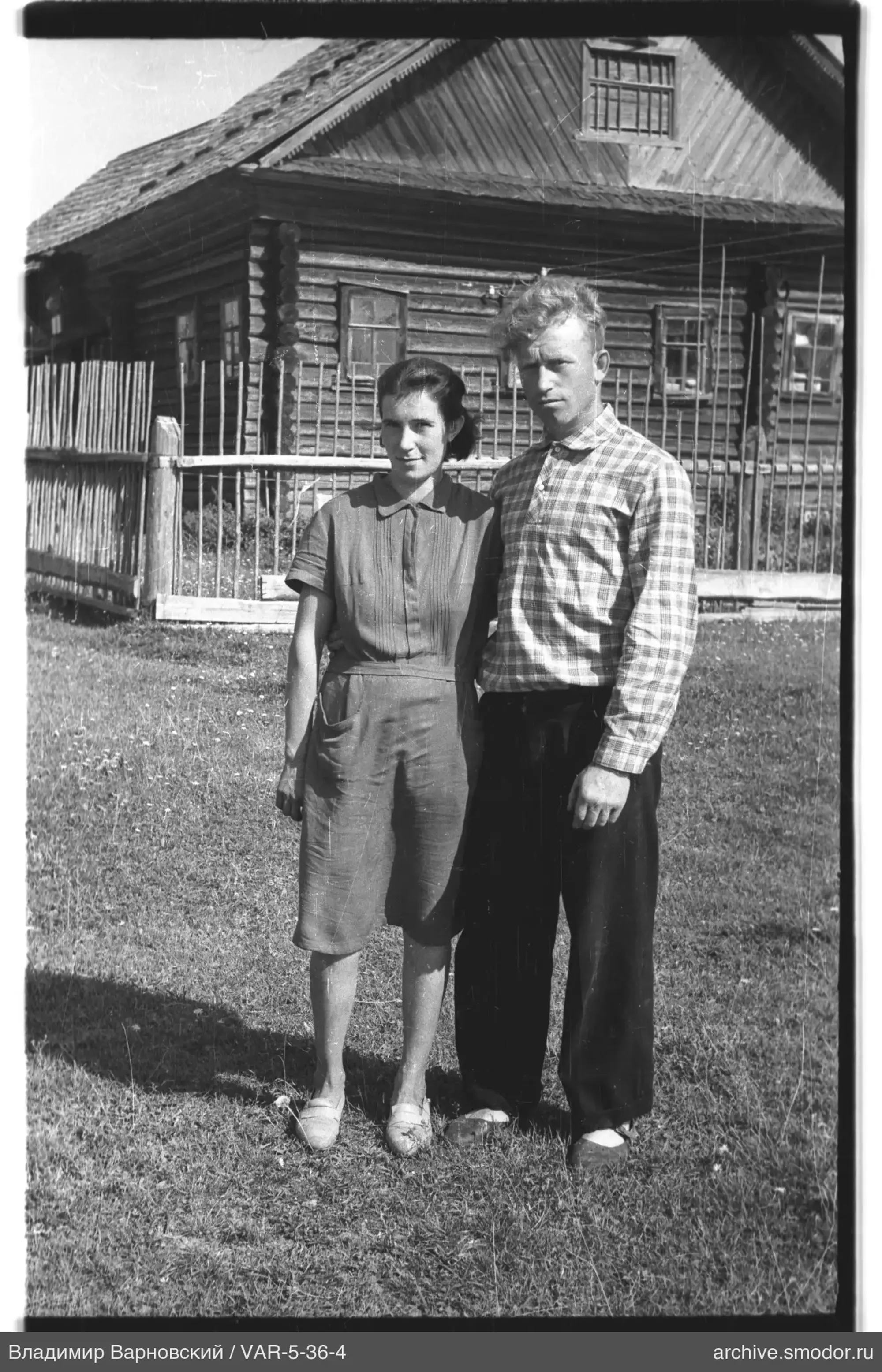 Mann und Frau vor einem Holzhaus