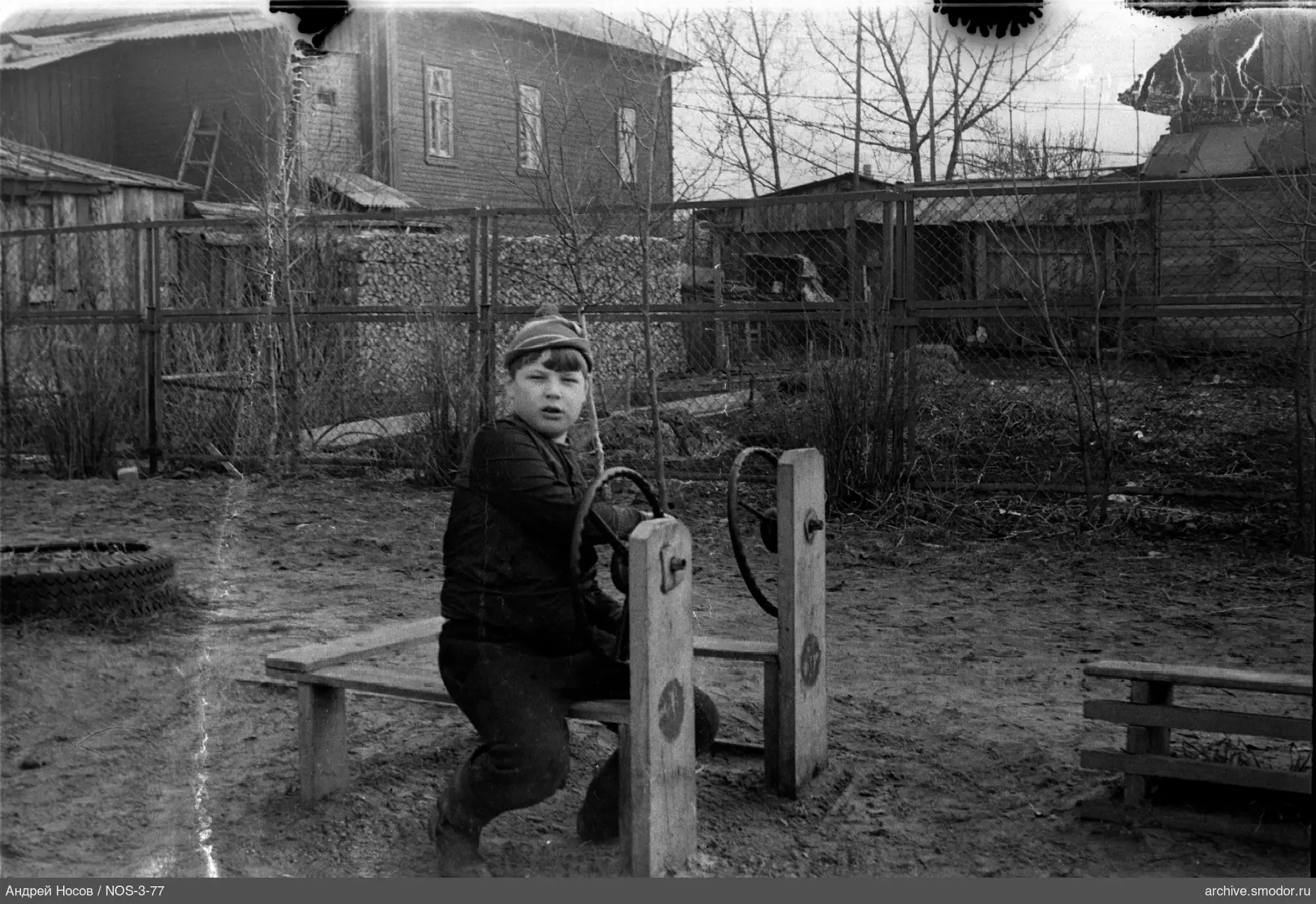 Boy sitting on a bench with steering wheels