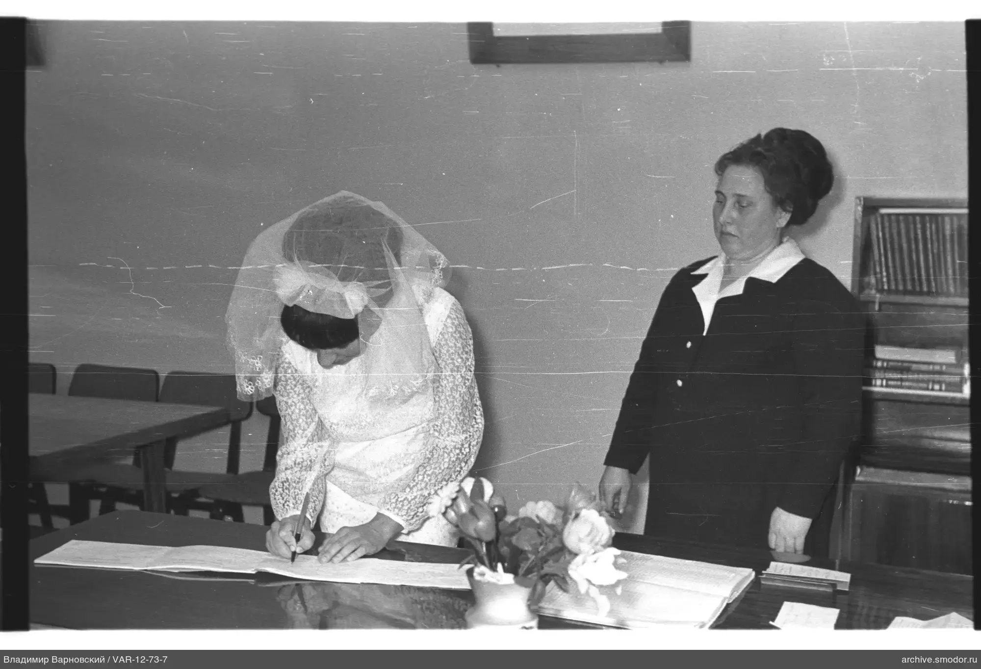 Woman in white lace dress signing a document