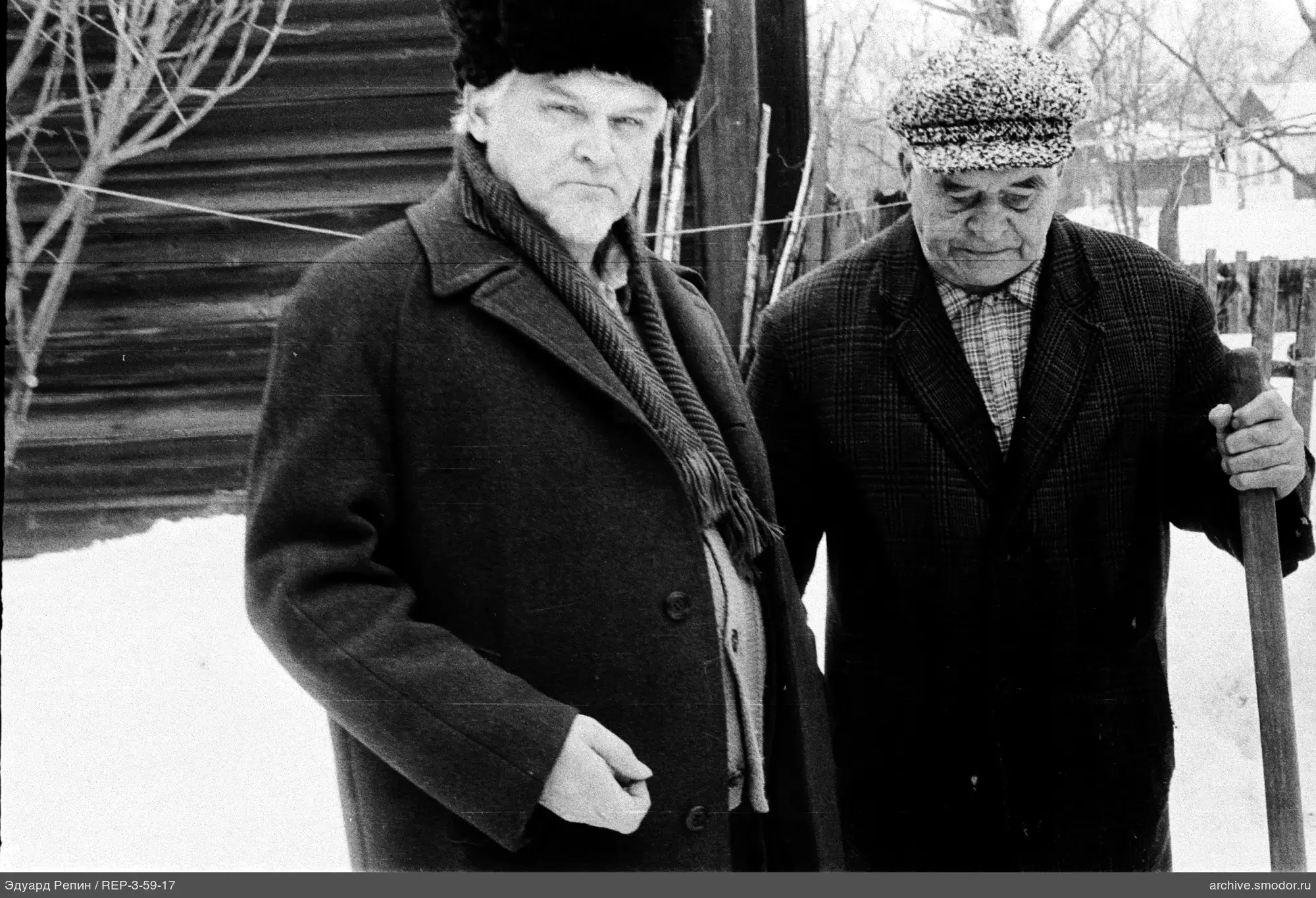 Два пожилых мужчины на снегу у дома