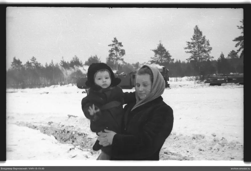 Frau mit Kind vor Winterlandschaft und Zug