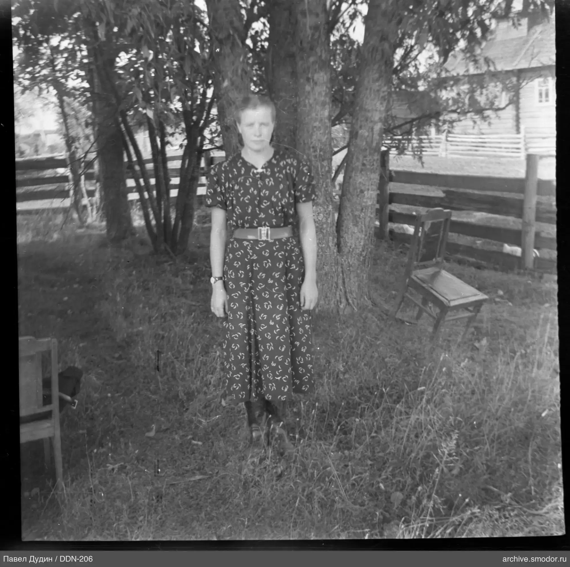 Woman standing on grass by a tree