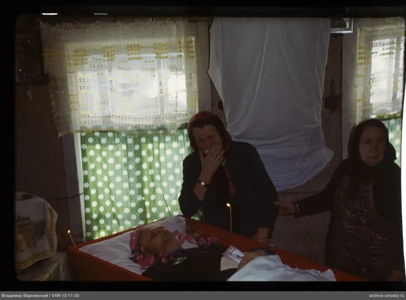 Man in coffin with women nearby