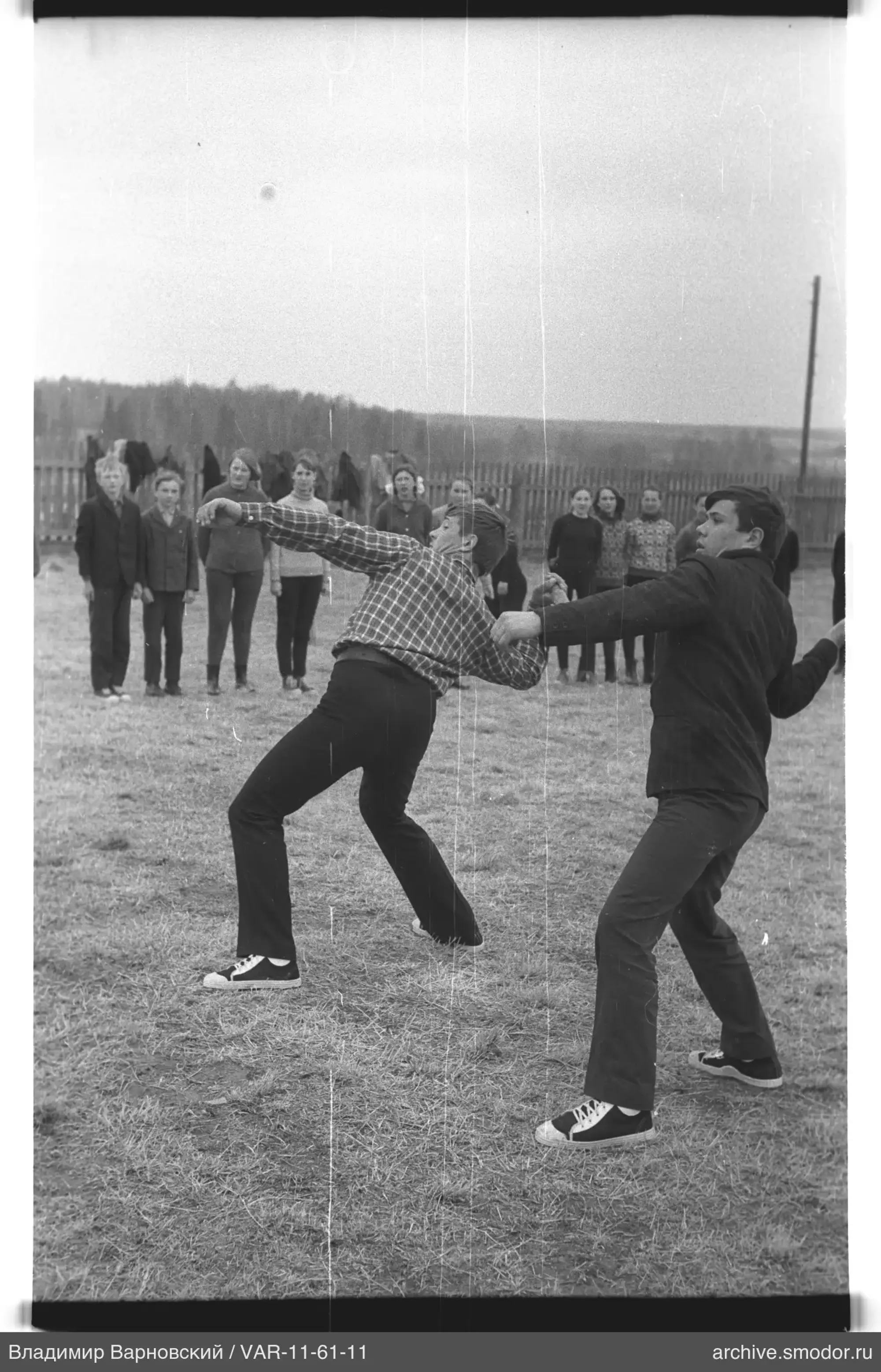 Young men perform shot put throw