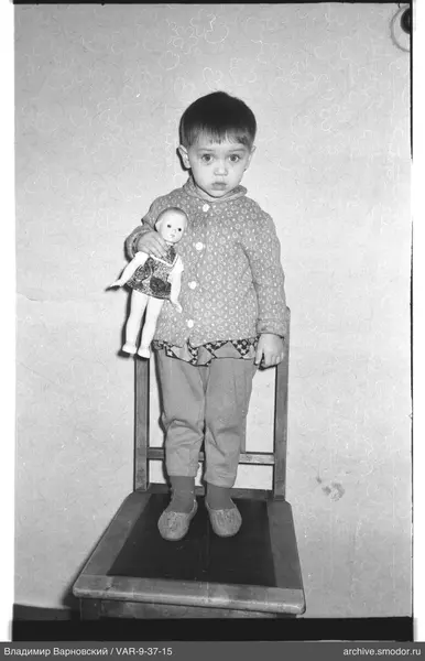 Child with doll on chair