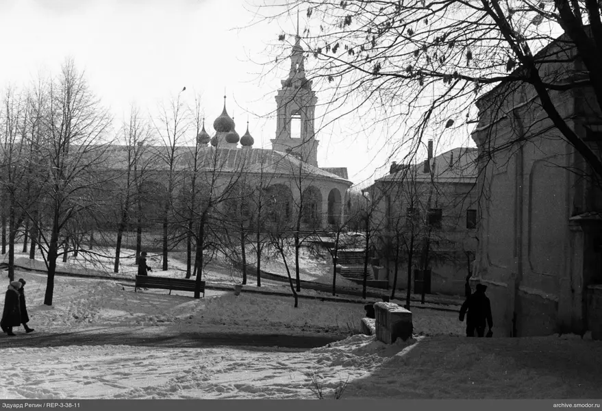Заснеженная тропинка с прохожими и зданиями