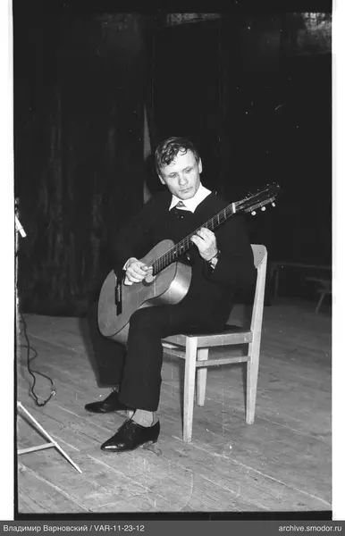 Man playing guitar on wooden floor