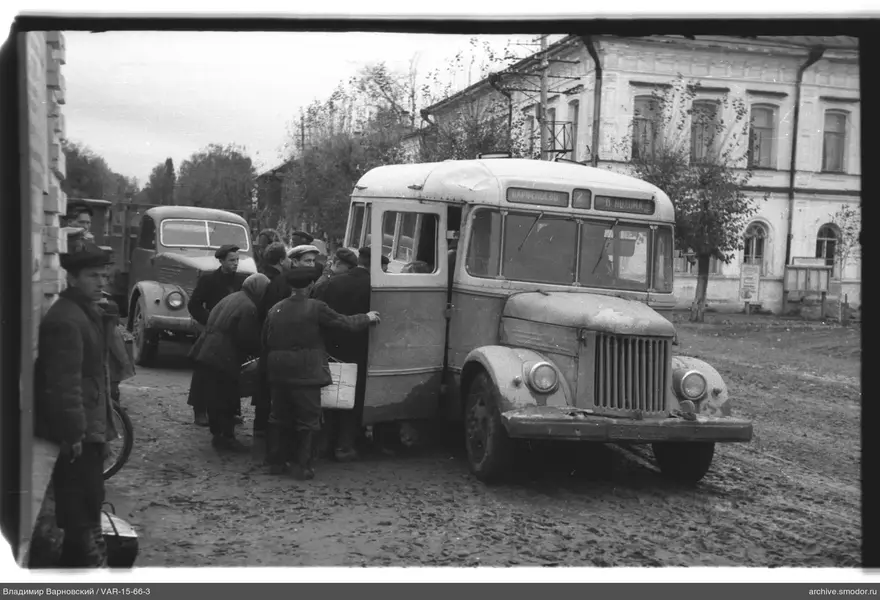 Gruppe von Menschen bei Bus mit Aufschriften