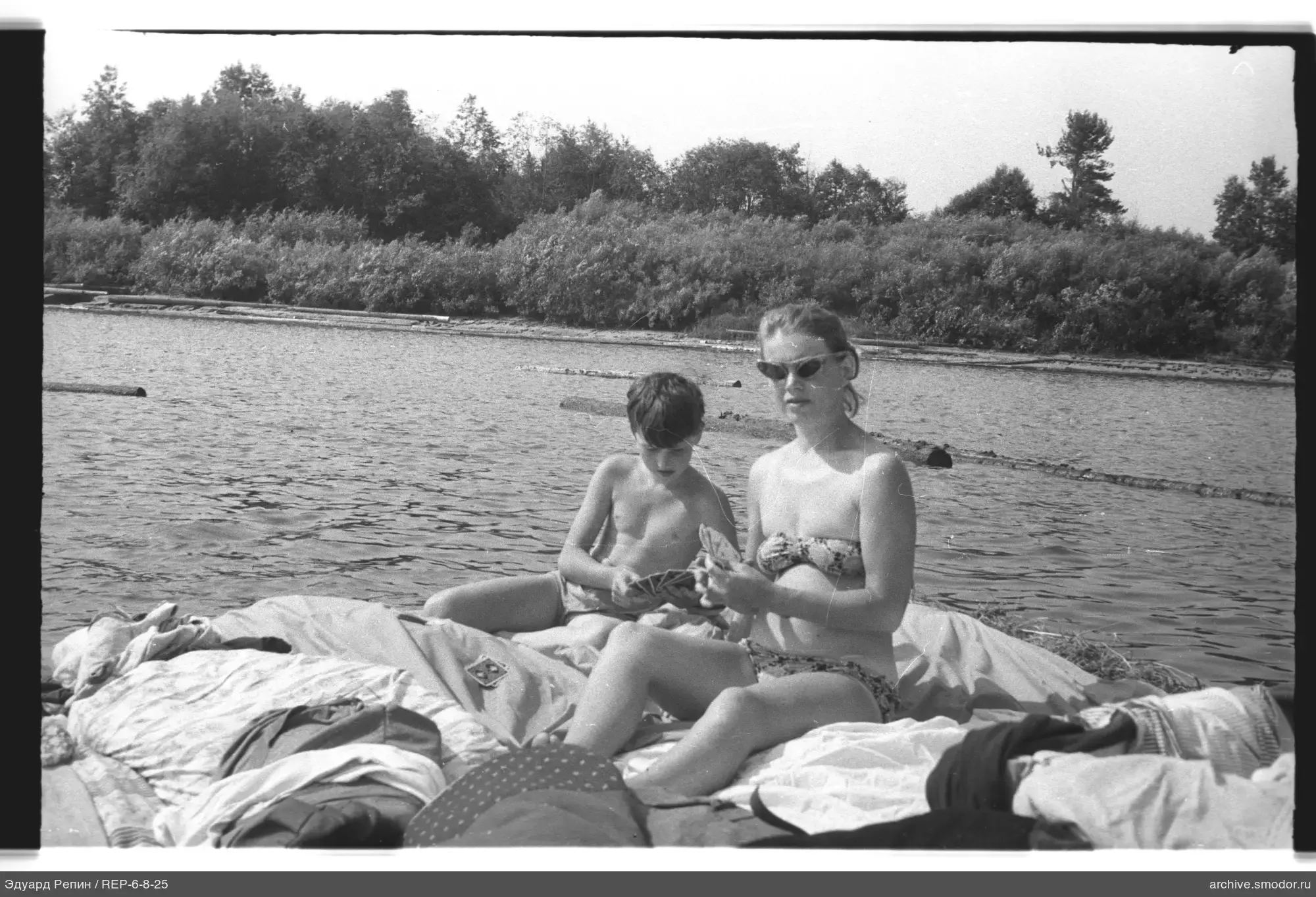 Frau und Junge mit Karten am Wasser
