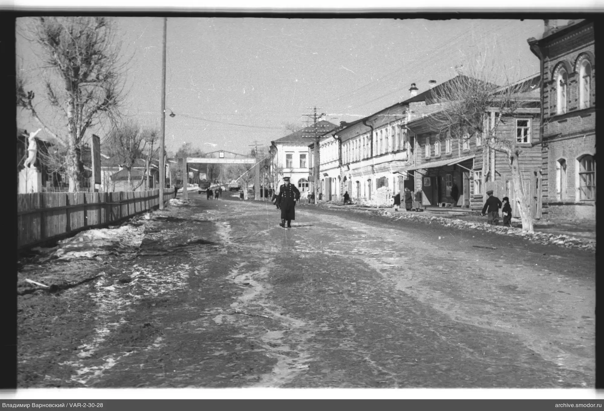 Straße mit Passanten und Skulptur