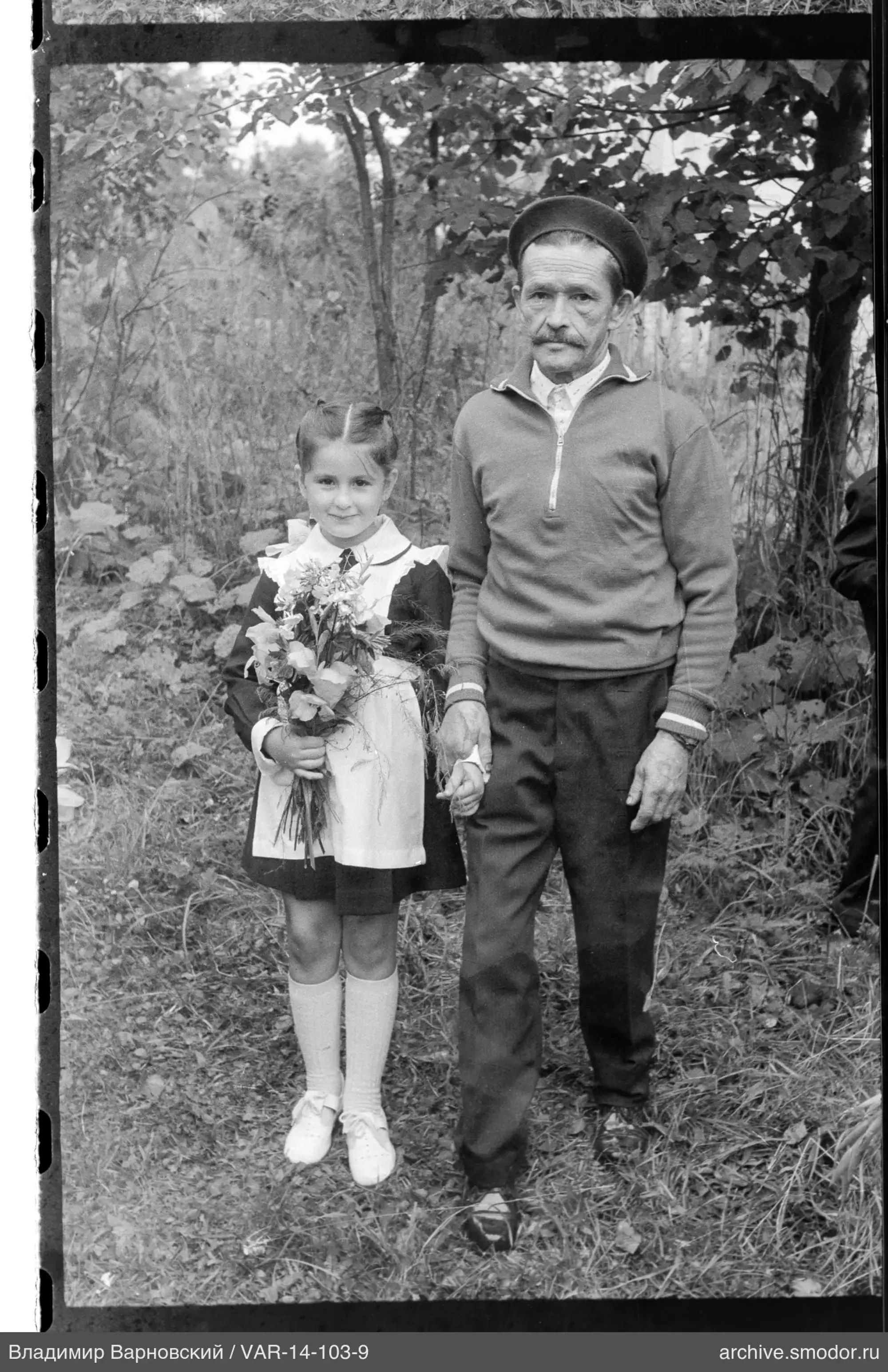 Mädchen mit Blumenstrauß und Mann auf Lichtung