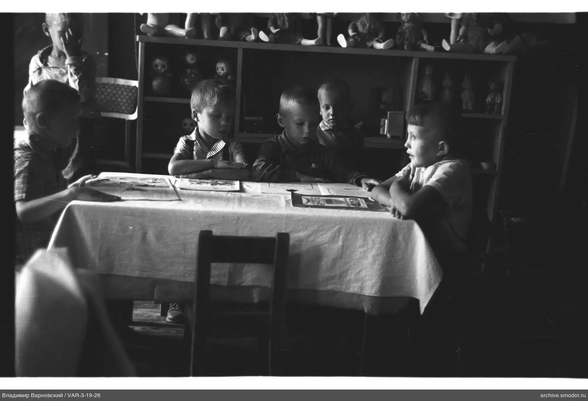 Kinder am Tisch mit Büchern und Spielzeug