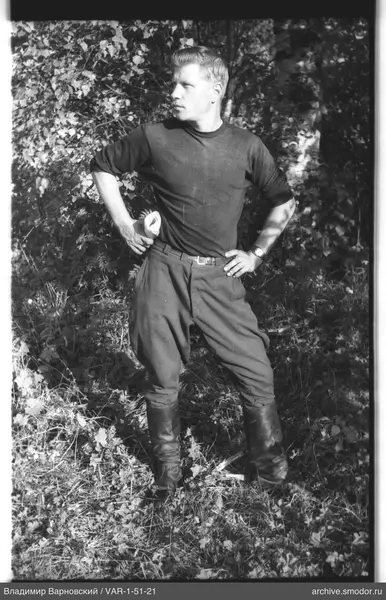 Man with rolled paper in front of trees
