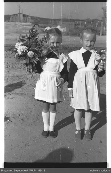 Zwei Mädchen mit Blumensträußen auf einer Straße