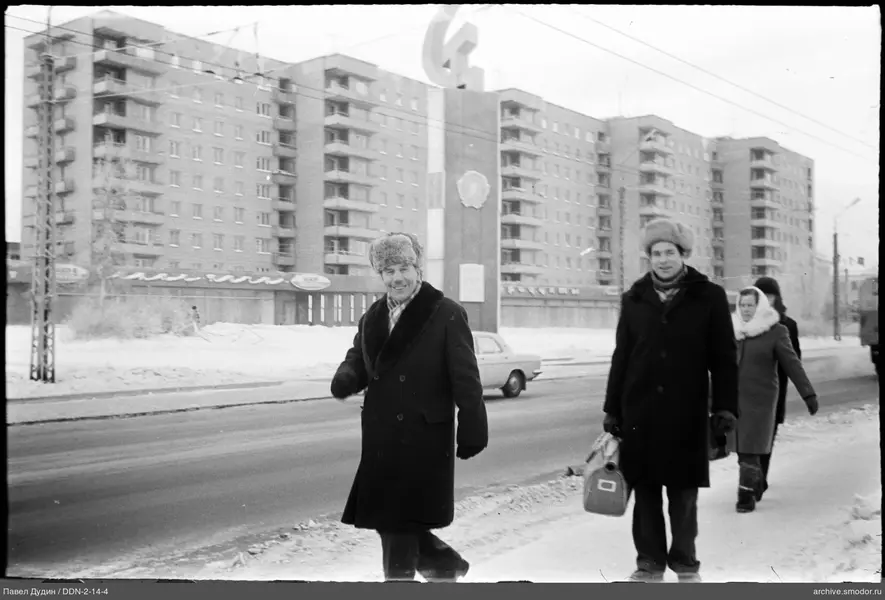 Люди на заснеженной улице у дома