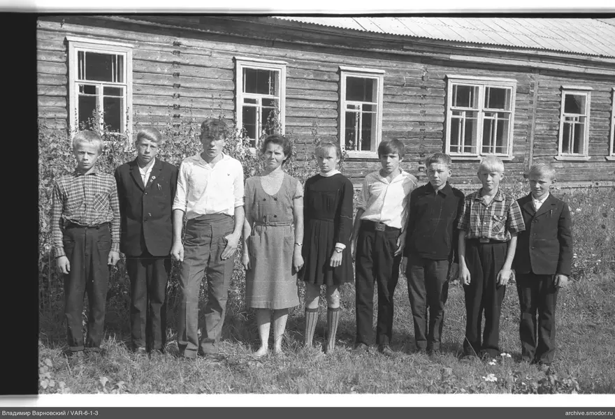 Gruppenporträt von Kindern vor einem Holzgebäude