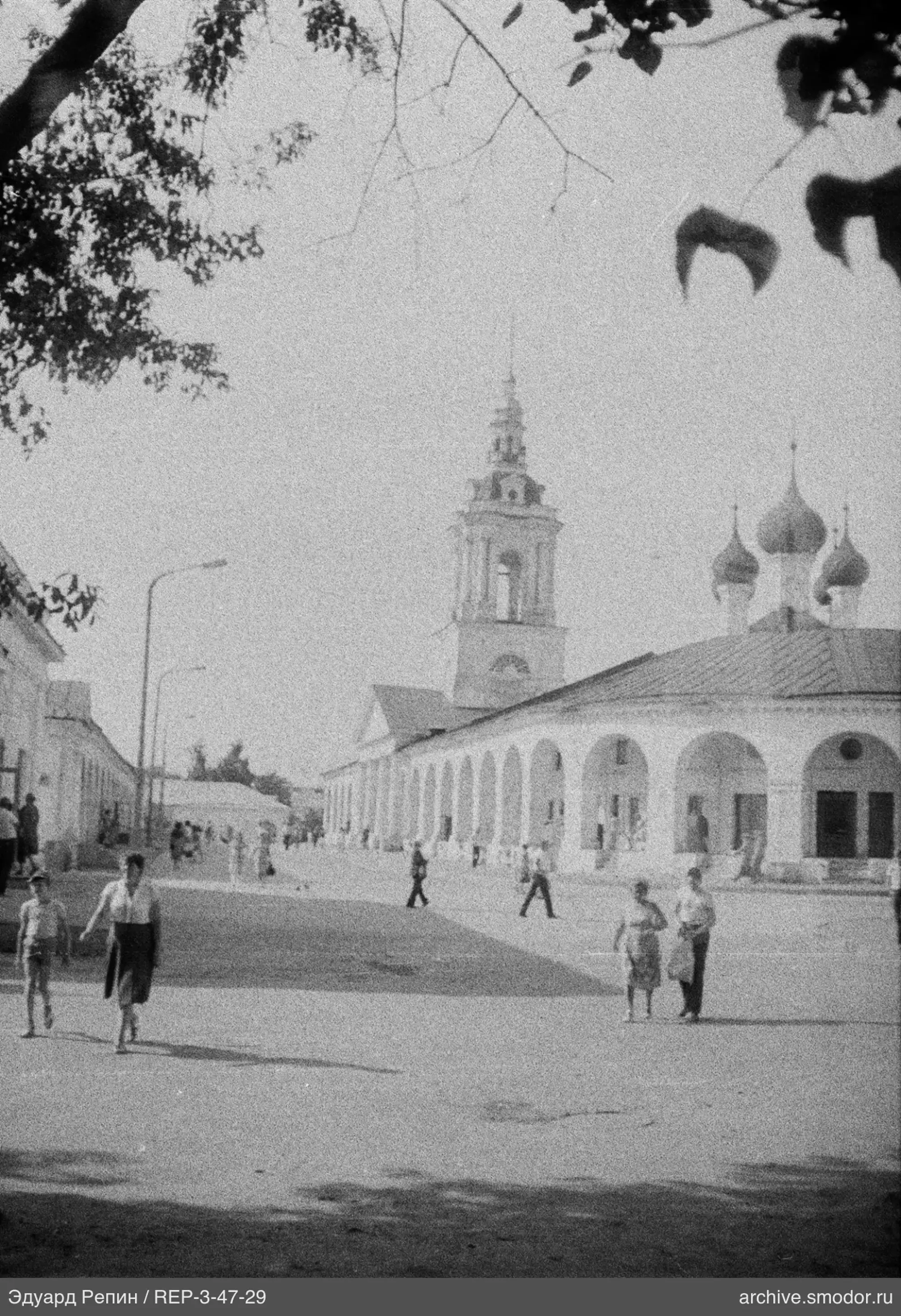 Улица с людьми и зданием с куполами