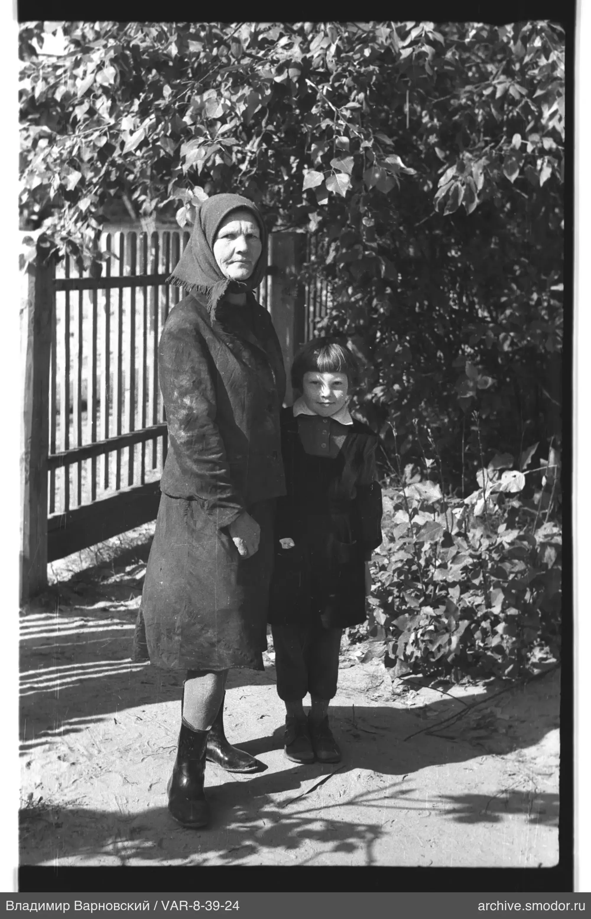 Woman and child by a wooden fence