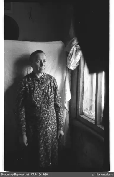 Frau am Fenster in langem Kleid