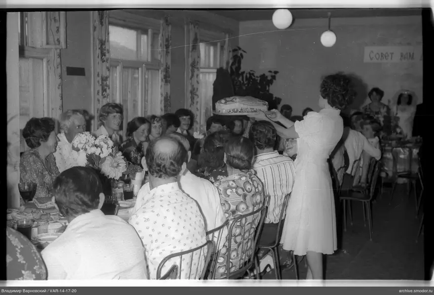 Frau mit Kuchen am langen Tisch