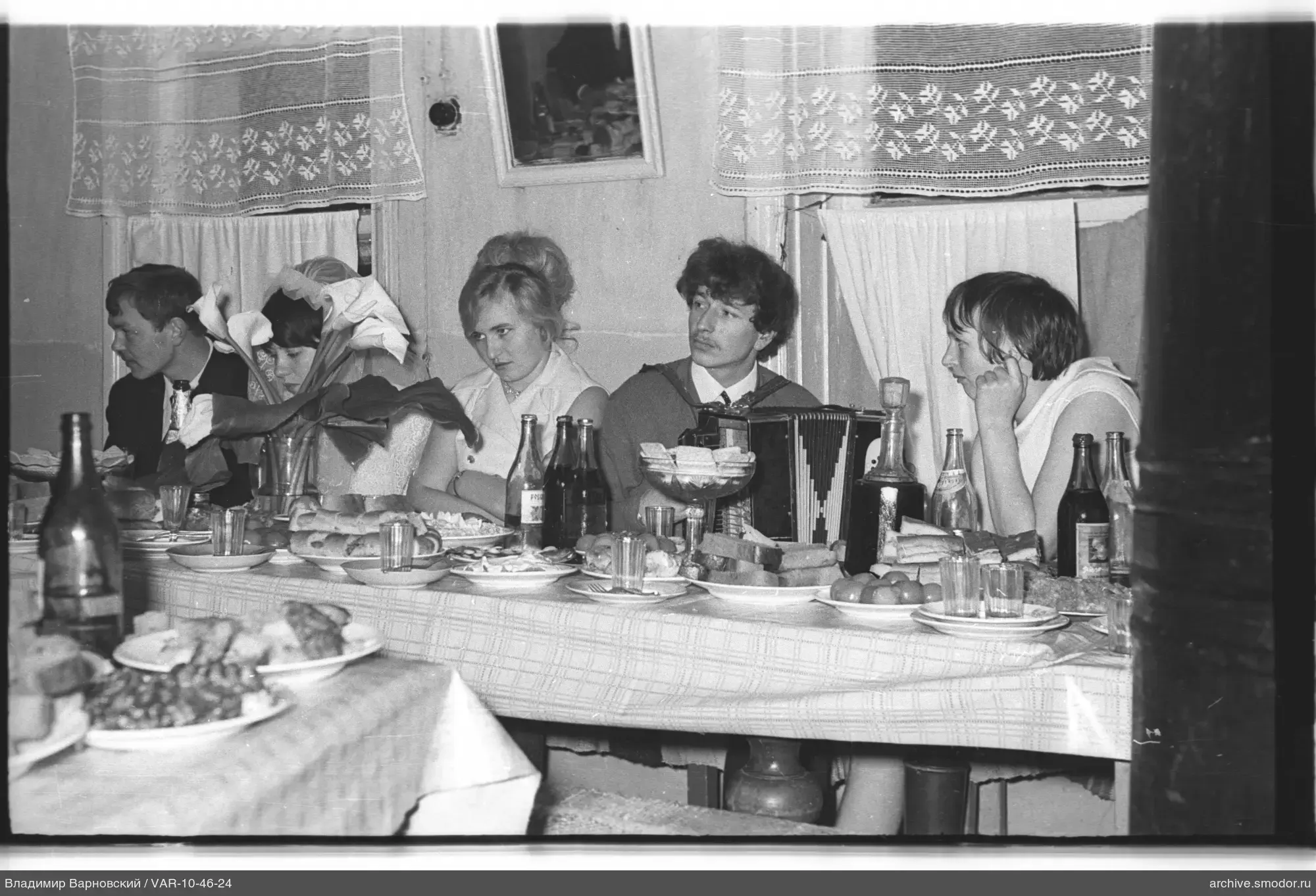 Gruppe am Tisch mit Essen und Akkordeon