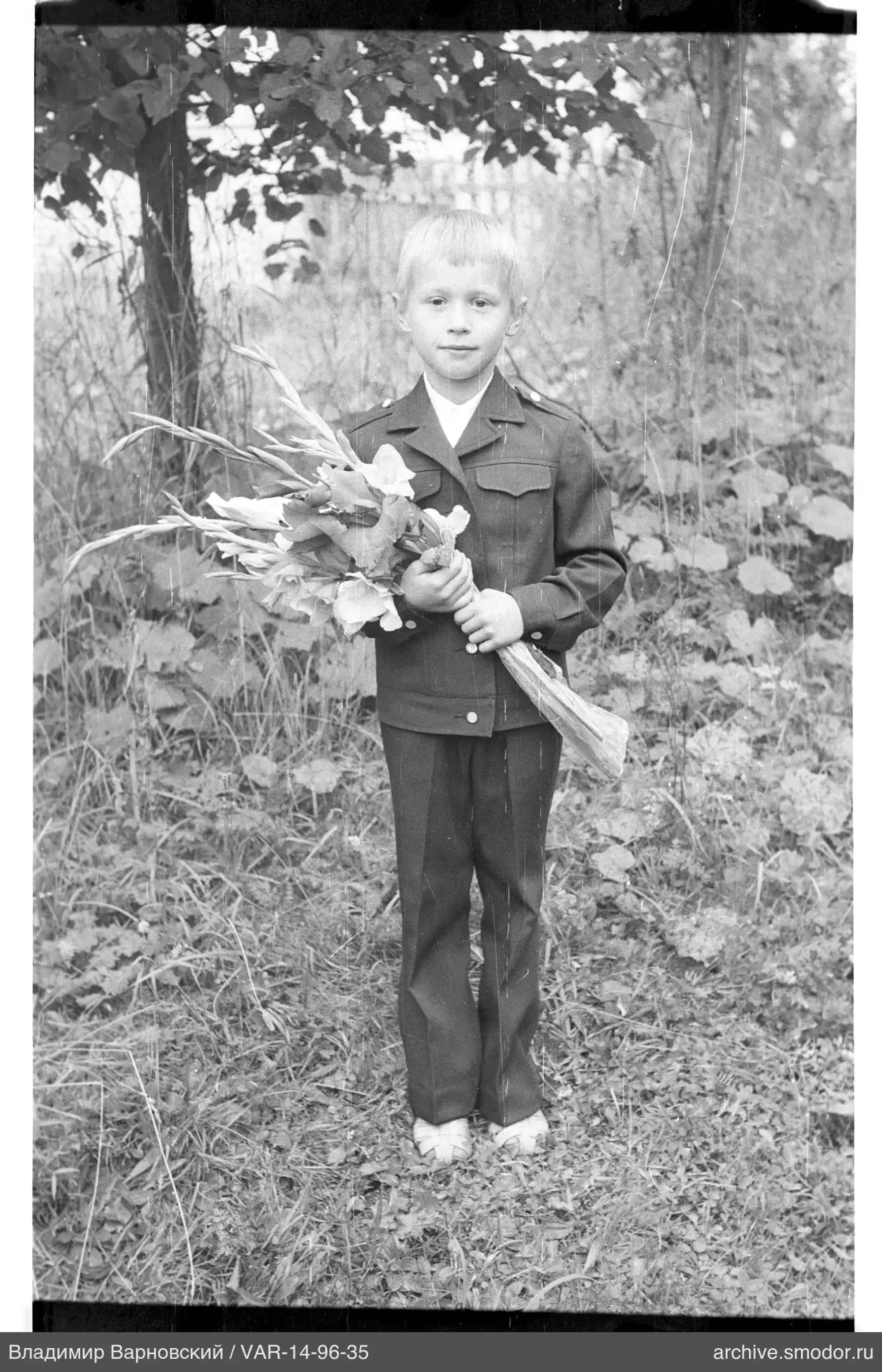 Boy with a bouquet of flowers in nature