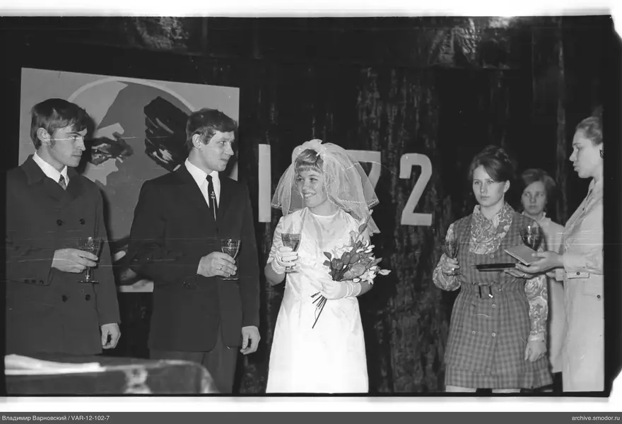 Gruppe von fünf Personen vor einem Vorhang mit 1972
