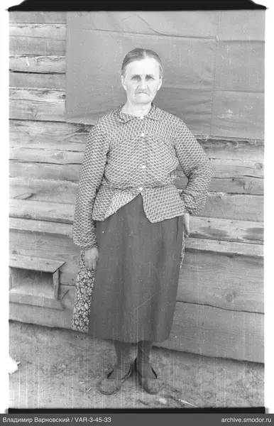 Full-length portrait of a woman by a wooden wall