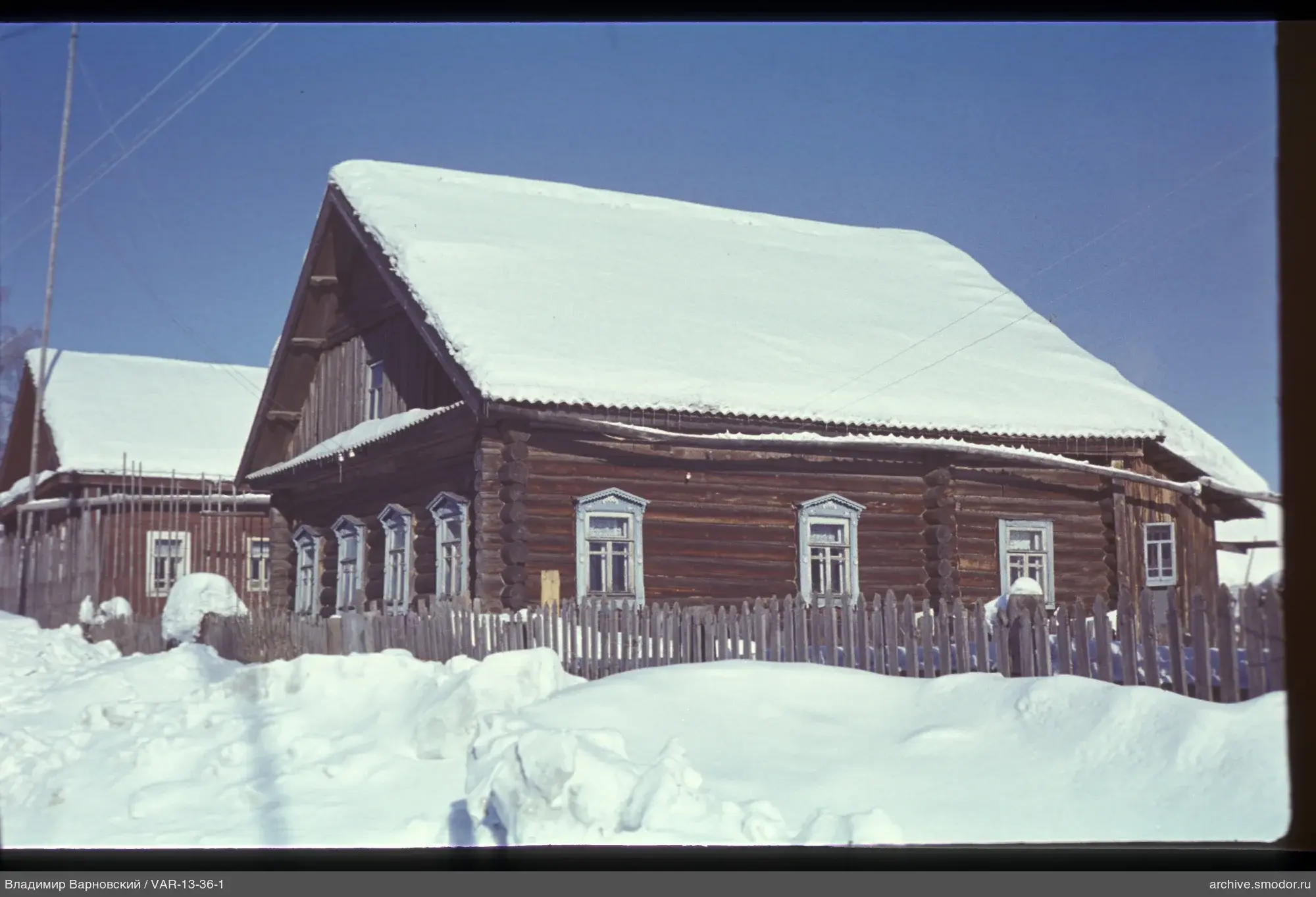 Wooden houses with snow-covered roofs