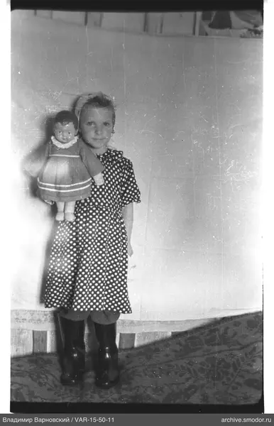 Mädchen mit Puppe an der Wand