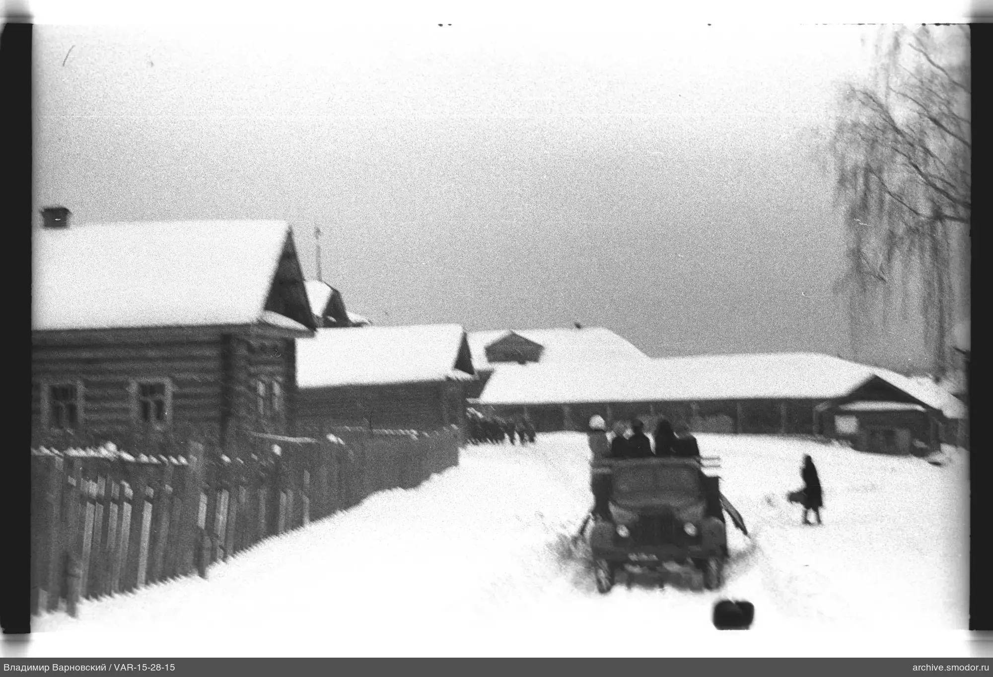 Заснеженная улица с домами и автомобилем
