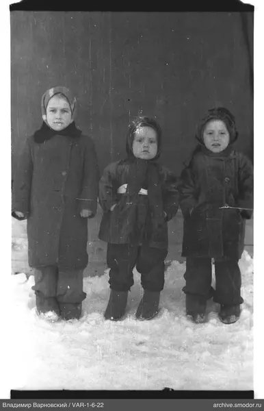 Kinder im Schnee vor einer Wand