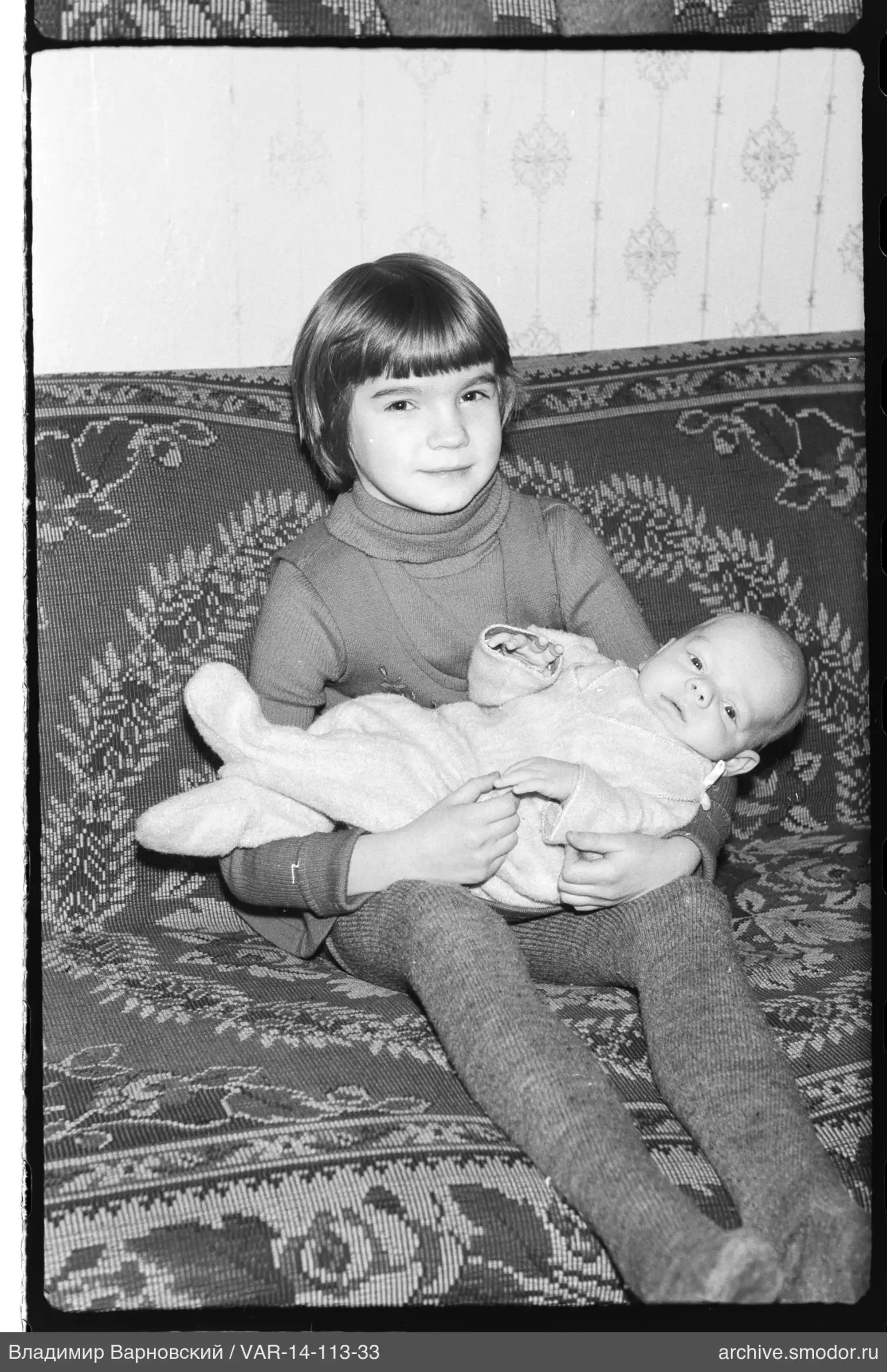 Mädchen mit Baby auf Sofa