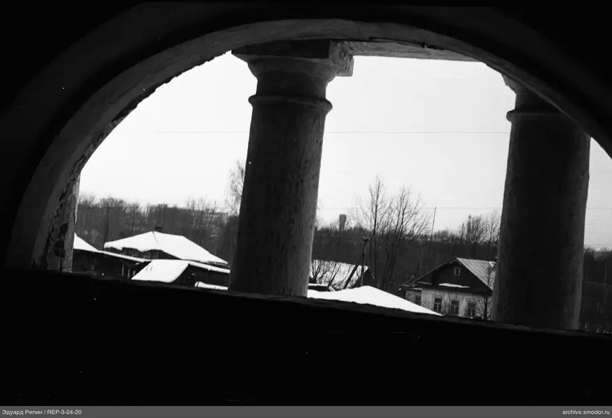 Blick durch einen Bogen auf verschneite Dächer