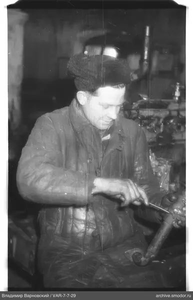Mann mit Metallteil und Schraubenzieher
