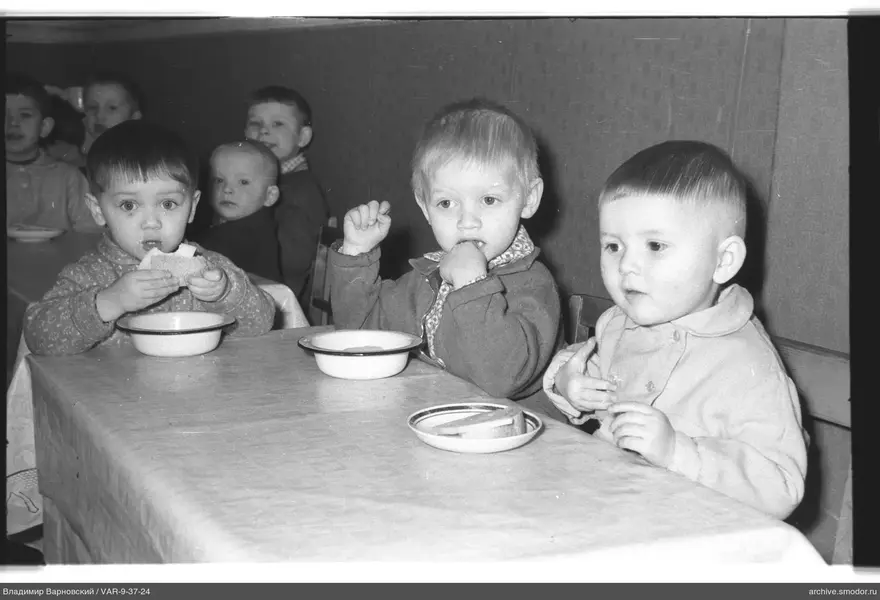 Children sitting at a table in a group photo