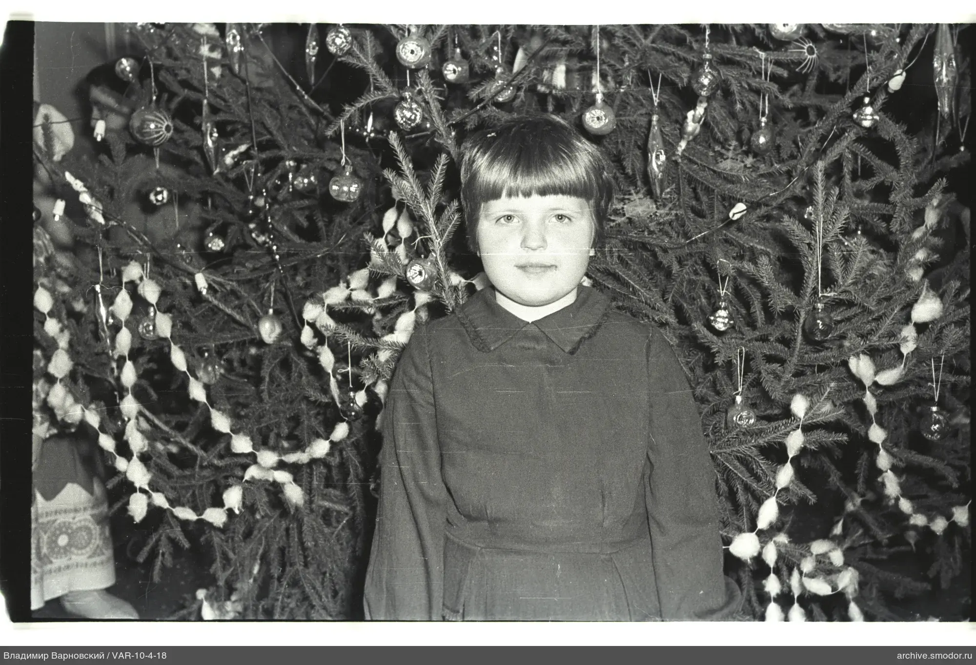 Mädchen vor geschmücktem Weihnachtsbaum
