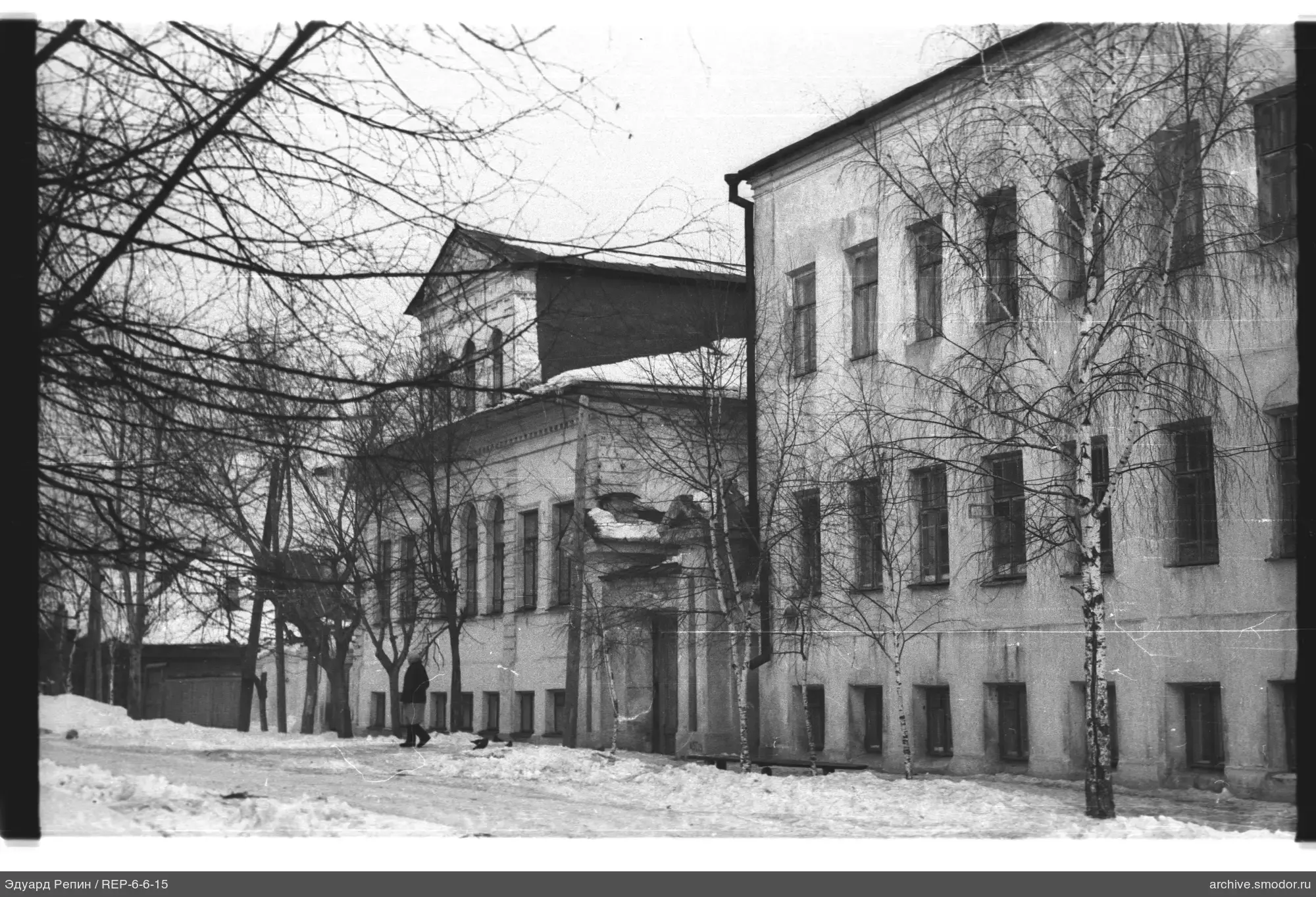 Zweistöckiges Gebäude mit Bäumen und Person