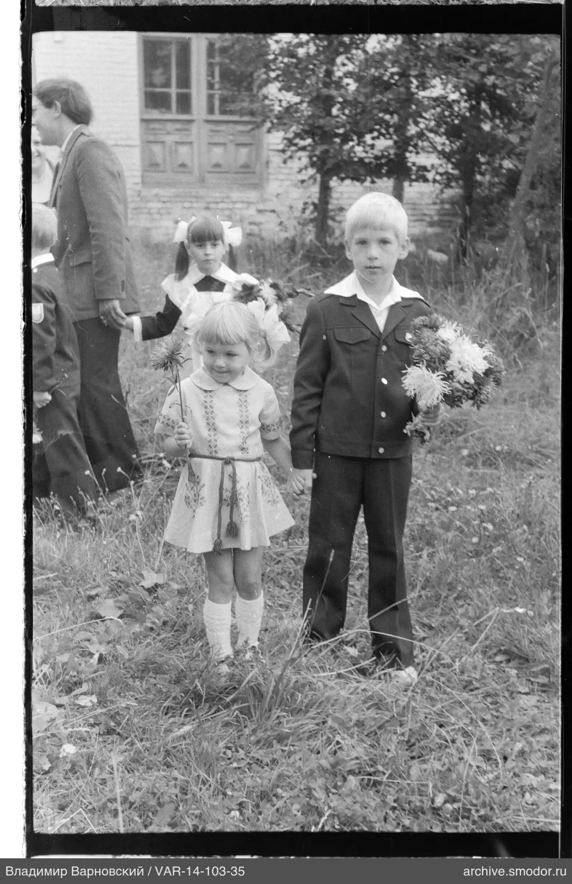 Group of children and woman with building background