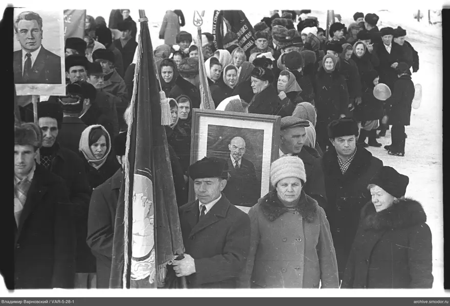 Группа людей на зимней улице с портретами и флагами