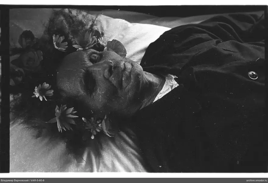 Mann mit Blumenkranz auf Bett liegend