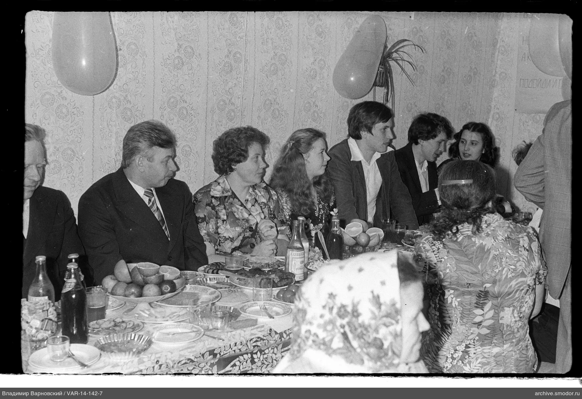 Gruppe am Tisch mit Geschirr und Früchten