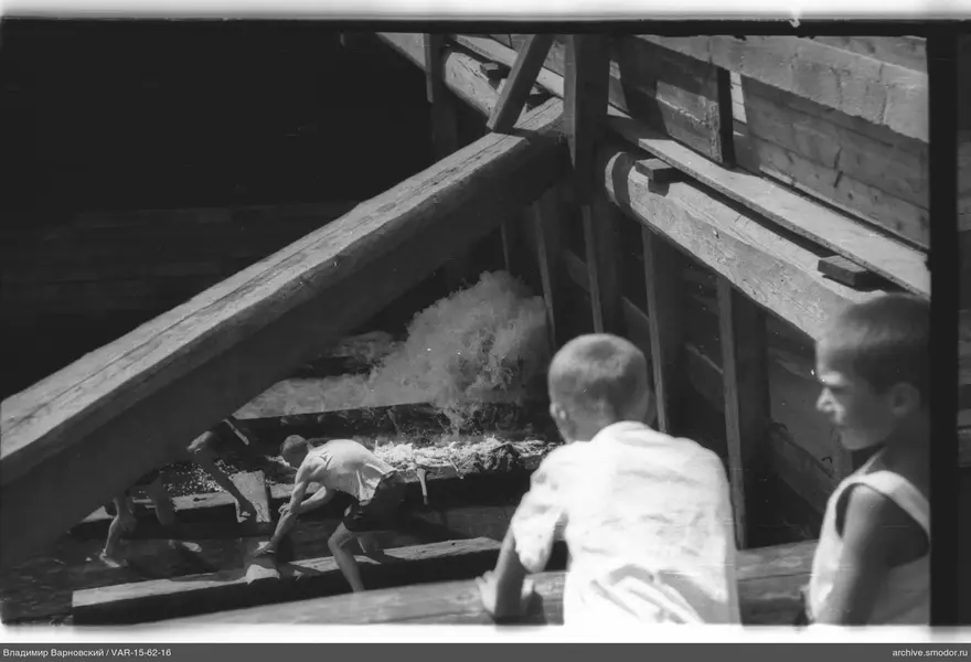 Jungen auf Holzstruktur und im Wasser